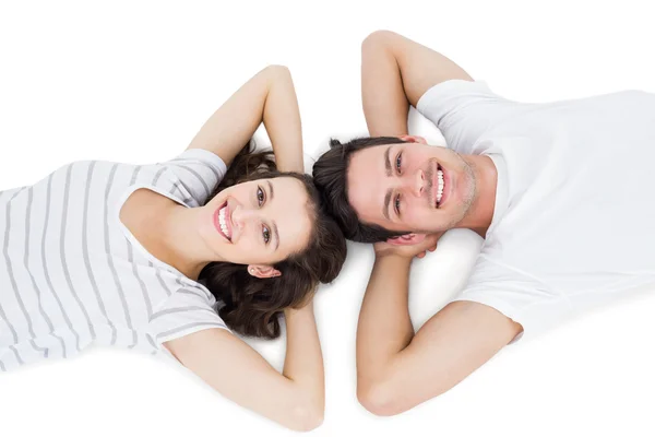 Happy couple lying on the floor head to head — Stock Photo, Image