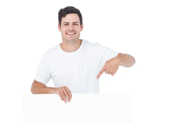 Bonito homem apontando um cartaz branco — Fotografia de Stock