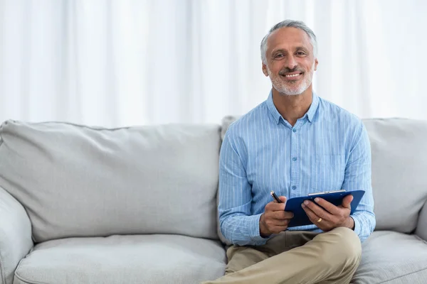 Felice medico scrivendo sugli appunti — Foto Stock