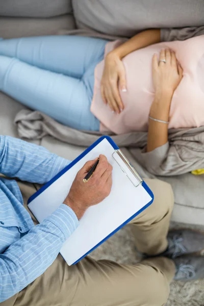 Doctor writing consulting pregnant woman — Stock Photo, Image