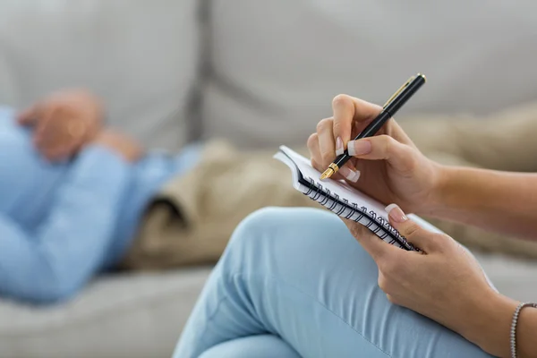Kobieta lekarz pisania na notatnik — Zdjęcie stockowe