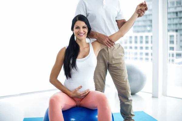 Arzt gibt schwangere Frau Physiotherapie — Stockfoto