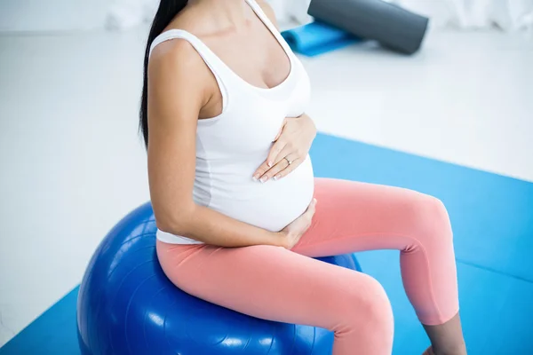 Mulher grávida se exercitando em bola de exercício — Fotografia de Stock