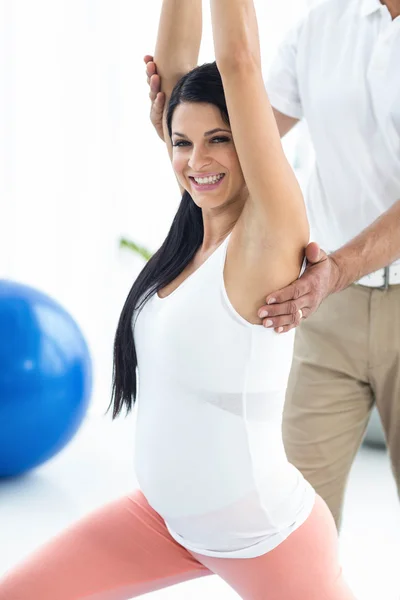 Врач проводит физиотерапию беременной женщине — стоковое фото