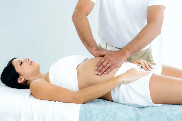Zwangere vrouw een maag massage ontvangen masseur — Stockfoto