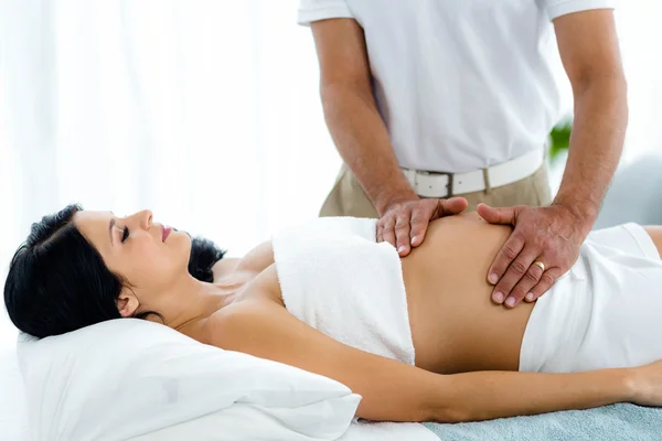 Беременная женщина получает массаж желудка — стоковое фото