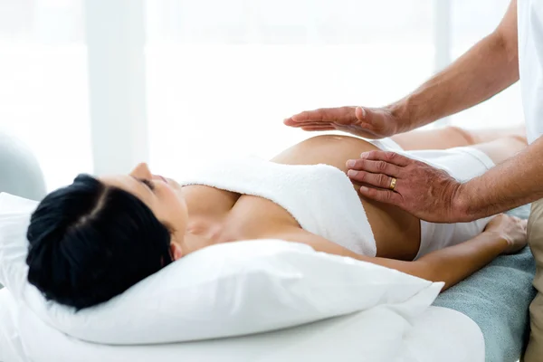 Schwangere Frau erhält eine Bauchmassage vom Masseur — Stockfoto