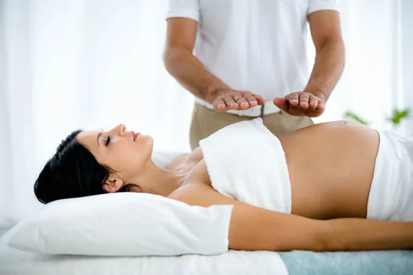 Pregnant woman receiving a stomach massage