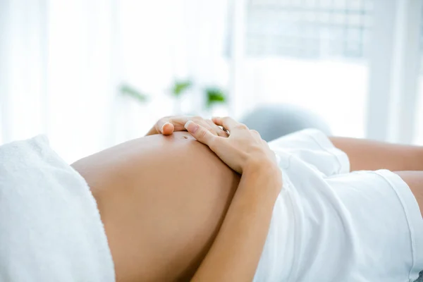 Gravid kvinna avkopplande på massagebänk — Stockfoto