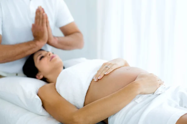 Gravid kvinna tar emot en spa-behandling från massör — Stockfoto