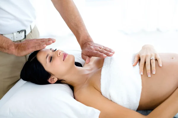 Pregnant woman receiving a spa treatment from masseur — Stock Photo, Image