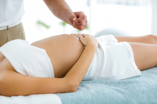 Pregnant woman receiving a spa treatment from masseur — Stock Photo, Image