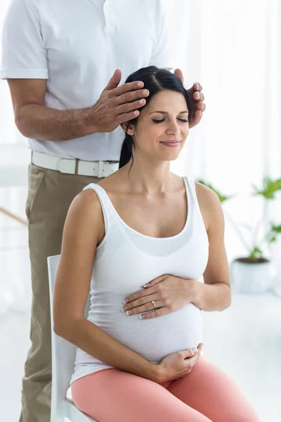 Zwangere vrouw een hoofdmassage ontvangen masseur — Stockfoto