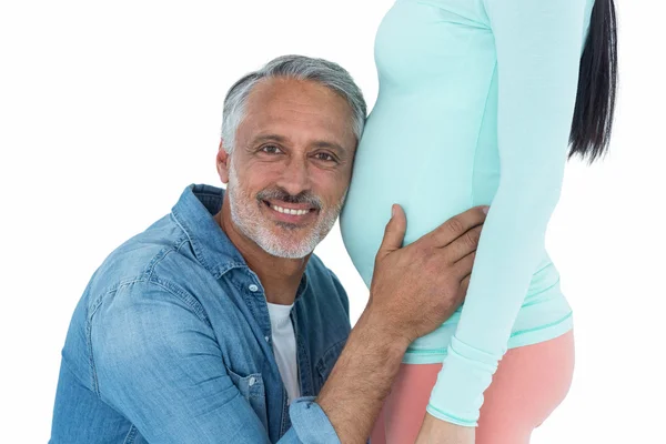 Man listening to pregnant womans stomach — Stock Photo, Image