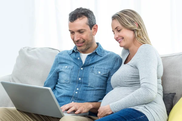 Couple sitting together and using laptop — Stock Photo, Image