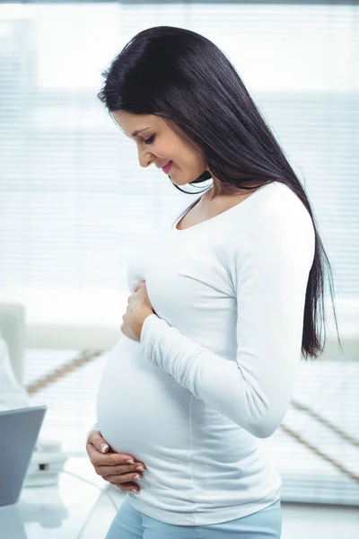 Mulher grávida segurando seu estômago — Fotografia de Stock
