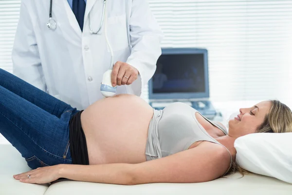 Pregnant woman receiving ultrasound treatment — Stock Photo, Image