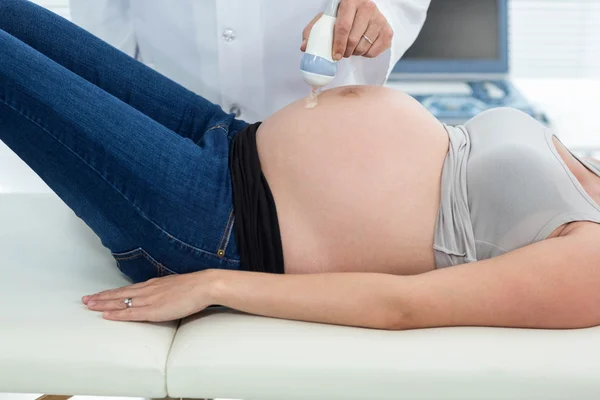 Pregnant woman receiving ultrasound treatment — Stock Photo, Image