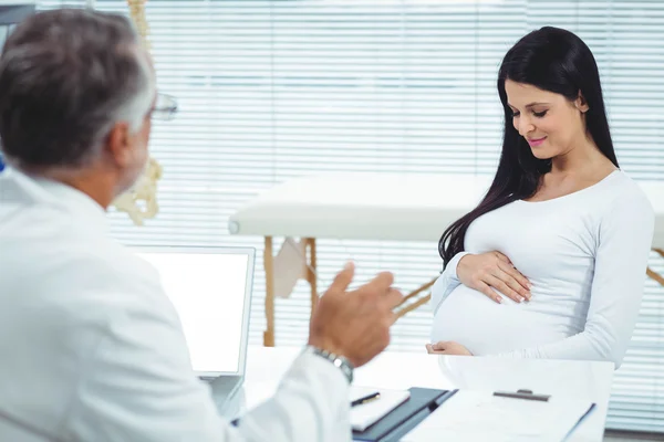 Zwangere vrouw interactie met arts bij kliniek — Stockfoto