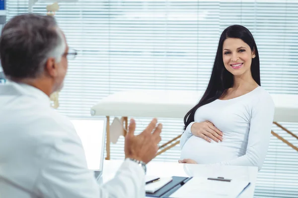Těhotná žena interakce s lékaři na klinice — Stock fotografie