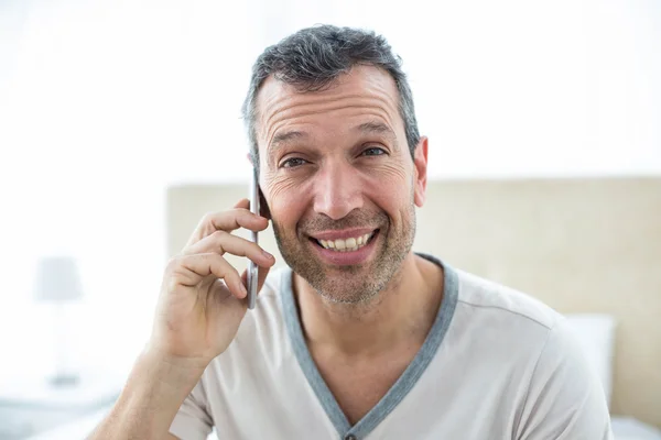 Hombre hablando en teléfono inteligente en el dormitorio — Foto de Stock
