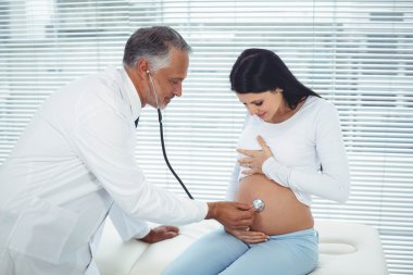 Doctor examining pregnant woman clipart