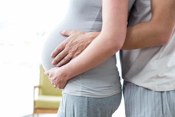 Uomo in possesso di donne incinte stomaco — Foto Stock