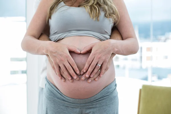 Hombre sosteniendo mujeres embarazadas estómago — Foto de Stock