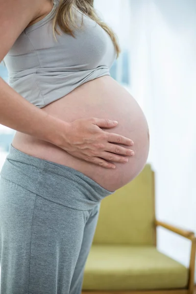 Mujer embarazada sosteniendo su estómago —  Fotos de Stock