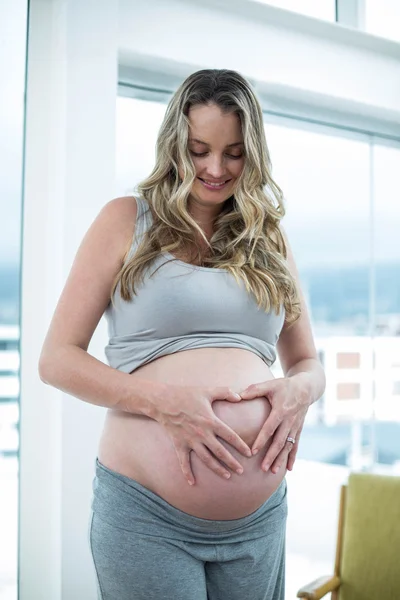 Mujer embarazada sosteniendo su estómago — Foto de Stock