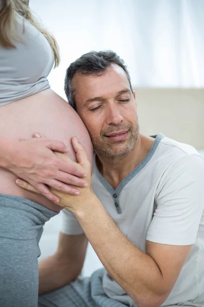 Adam hamile kadının mide için dinleme — Stok fotoğraf