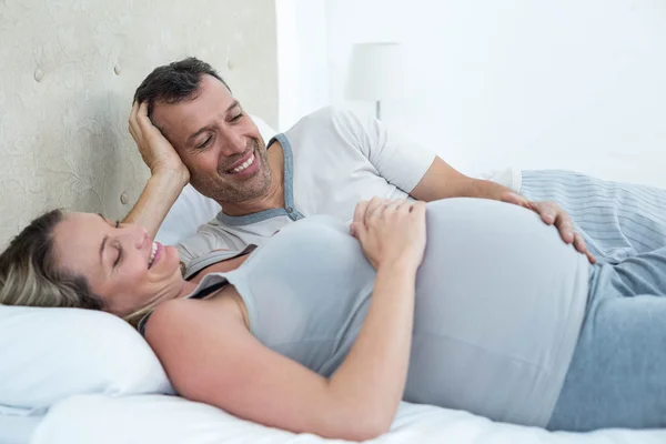 Esperando casal deitado na cama e conversando — Fotografia de Stock