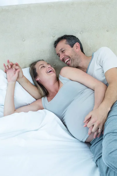 Esperando pareja acostada en la cama y charlando —  Fotos de Stock