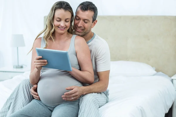 Esperando casal sentado na cama — Fotografia de Stock