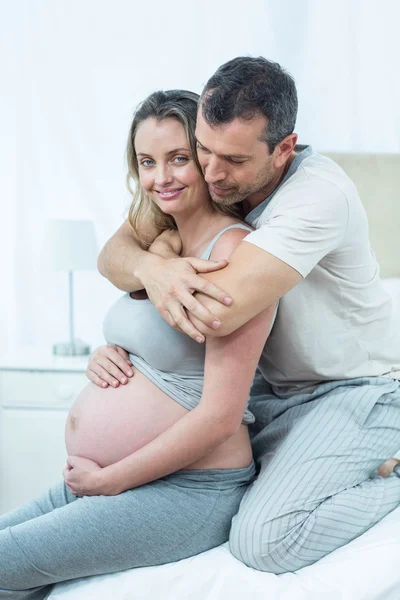 Aspettativa coppia seduta sul letto — Foto Stock