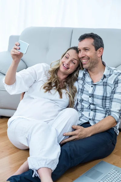 妊娠中のカップルに座って床 — ストック写真