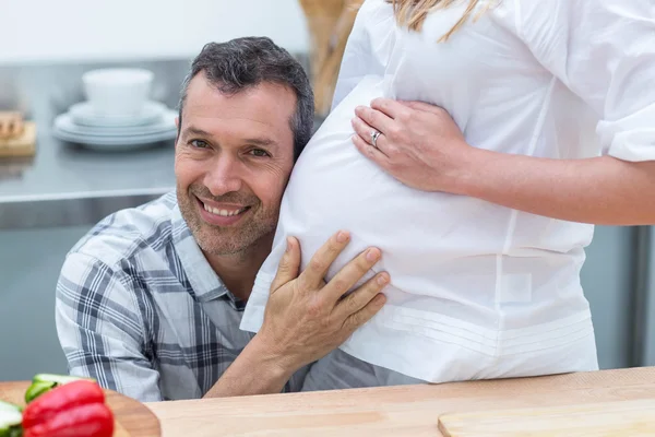 Homme écoutant le ventre de la femme enceinte — Photo