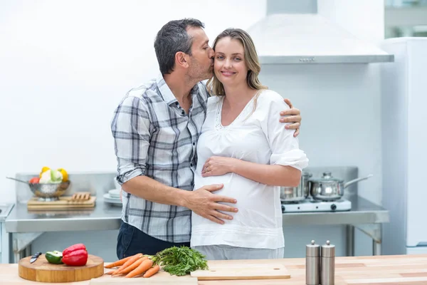 Homem beijando na bochecha da mulher grávida — Fotografia de Stock