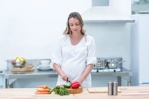 Mujer embarazada ocupada en la cocina — Foto de Stock