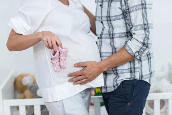 Pregnant couple holding baby shoes — Stock Photo, Image