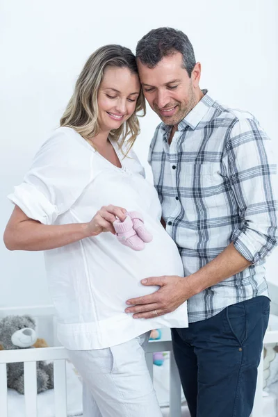 Couple enceinte tenant des chaussures de bébé — Photo