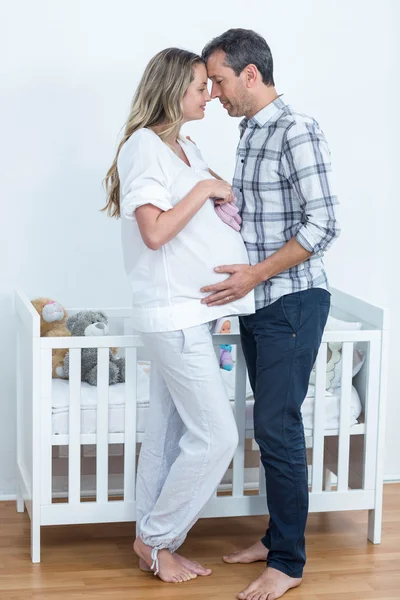 Casal grávida segurando sapatos de bebê — Fotografia de Stock