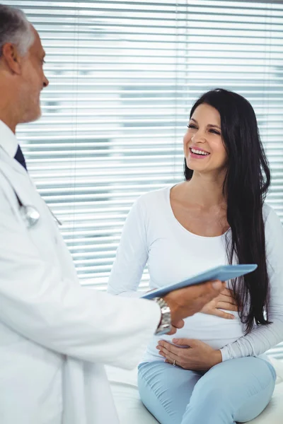 Mulher grávida interagindo com o médico — Fotografia de Stock