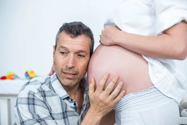 Homem ouvindo a barriga da mulher grávida — Fotografia de Stock