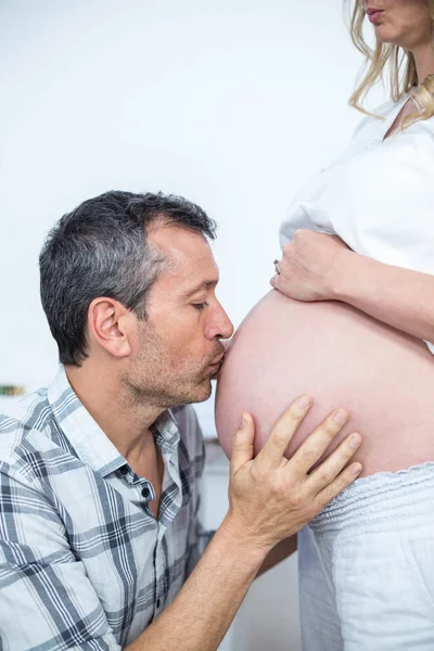 Homem beijando a barriga da mulher grávida — Fotografia de Stock