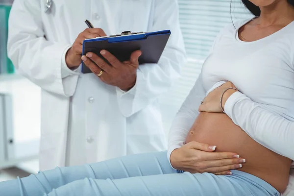 Donna incinta che interagisce con il medico — Foto Stock