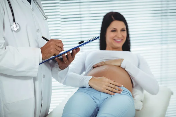 Donna incinta che interagisce con il medico — Foto Stock