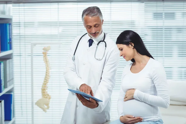 Mujer embarazada interactuando con el médico — Foto de Stock