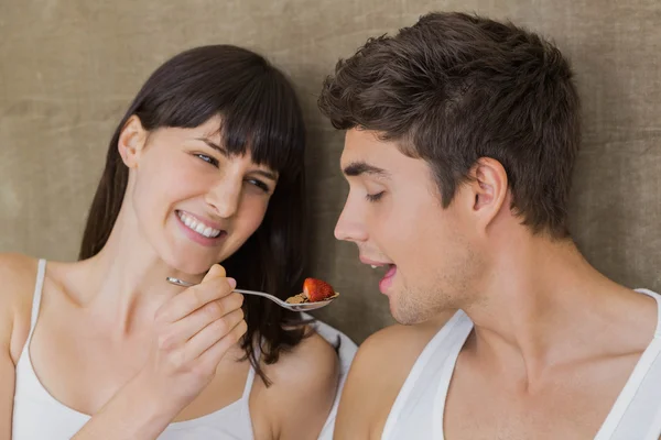 Mulher alimentando cereais café da manhã para o homem — Fotografia de Stock