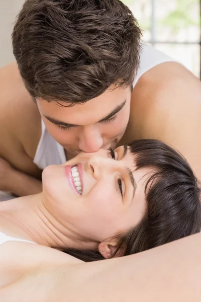 Mann küsst Frau auf Bett — Stockfoto